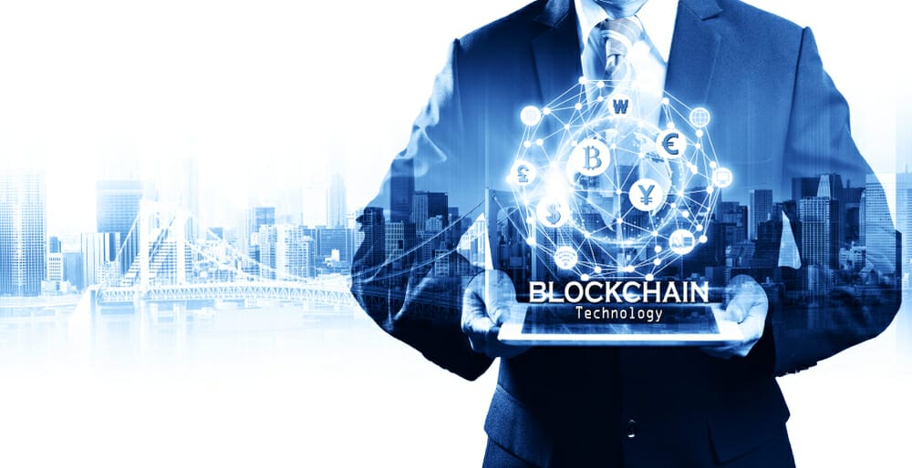Businessman,Hold,The,Blockchain,Hologram,On,Tablet,,Business,And,Technology,